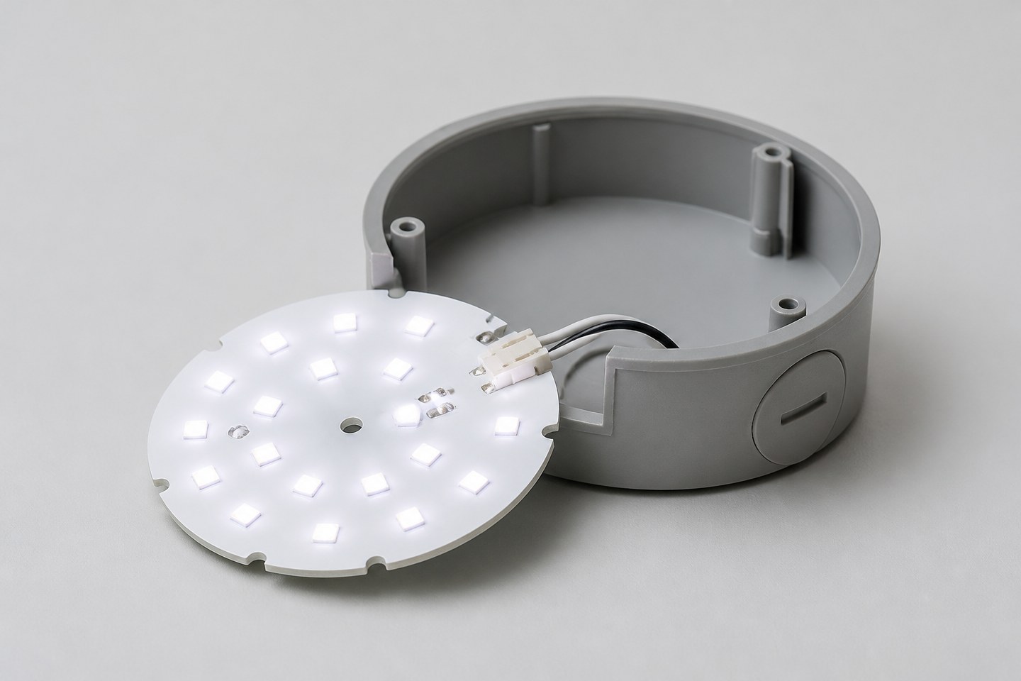 A small illuminated LED light board module partially inserted into a gray plastic housing.