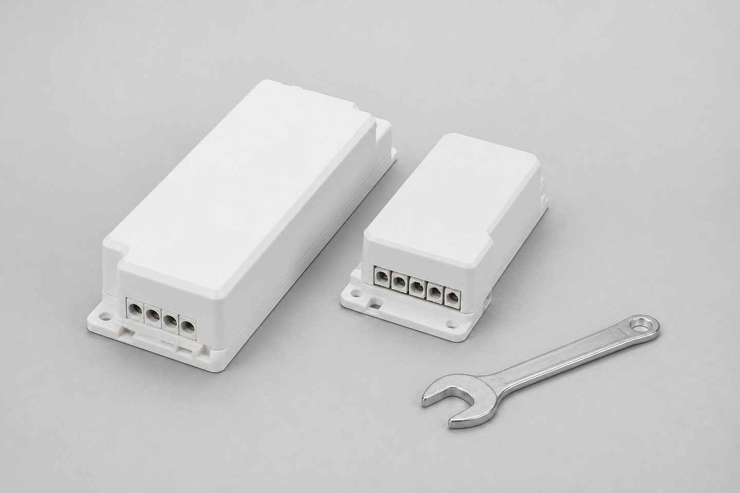 A white LED driver unit and a controller module placed side by side with a wrench nearby.