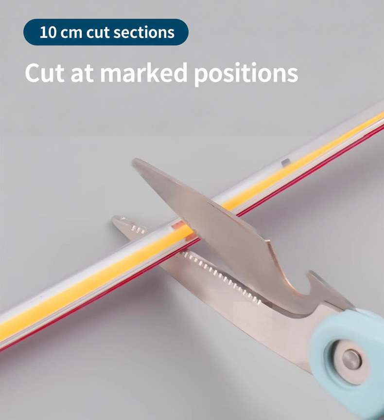 Scissors aligned with a marked cut section on the COB strip.
