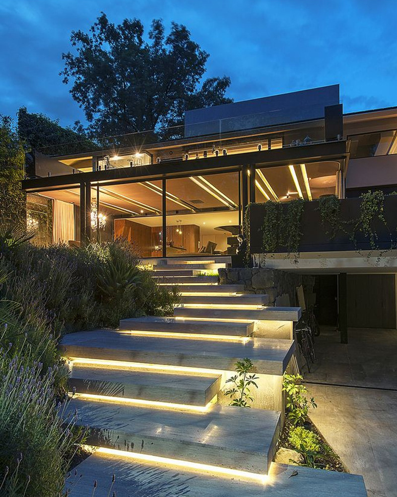 Warm linear lighting along outdoor steps and a terrace