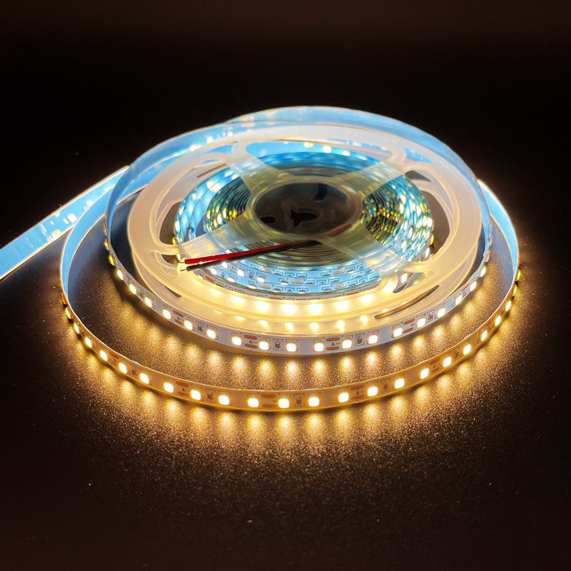 Warm-white LED strip illuminated on a reel.