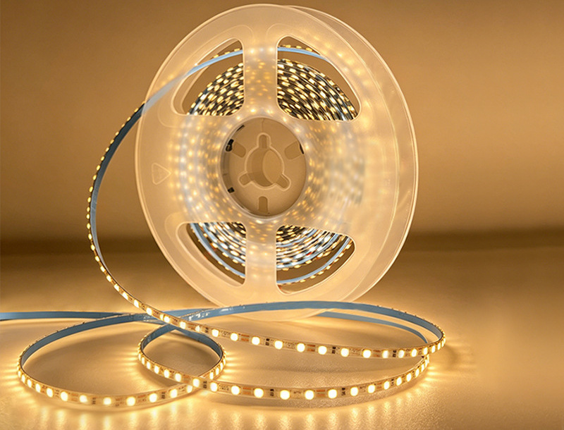 Warm-white narrow LED strip on a translucent reel.
