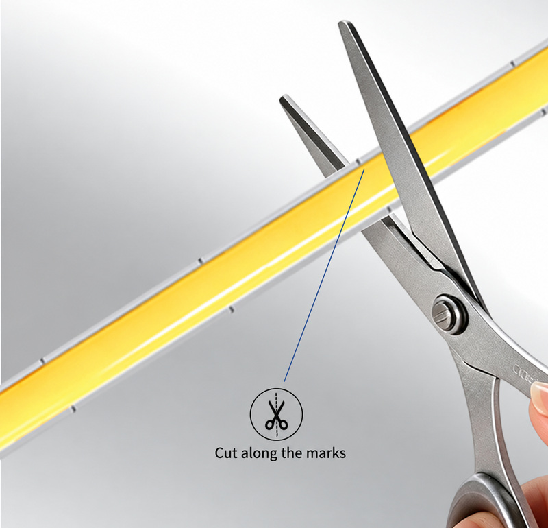 Scissors aligned with the marked cutting area of a narrow COB strip.