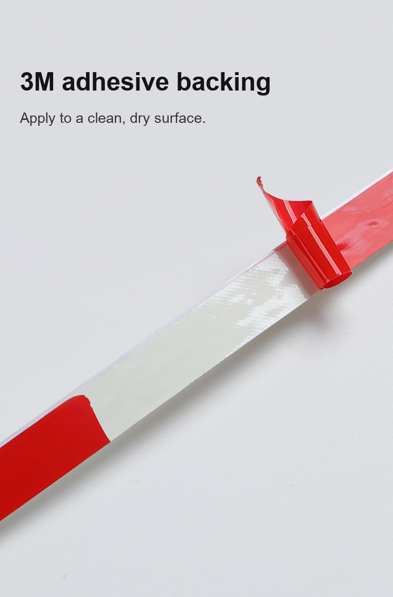 Red liner being peeled from the adhesive backing of an LED strip