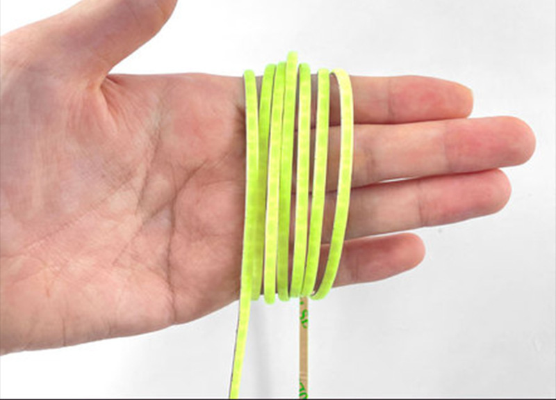 Ultra-narrow COB strip coiled across a hand